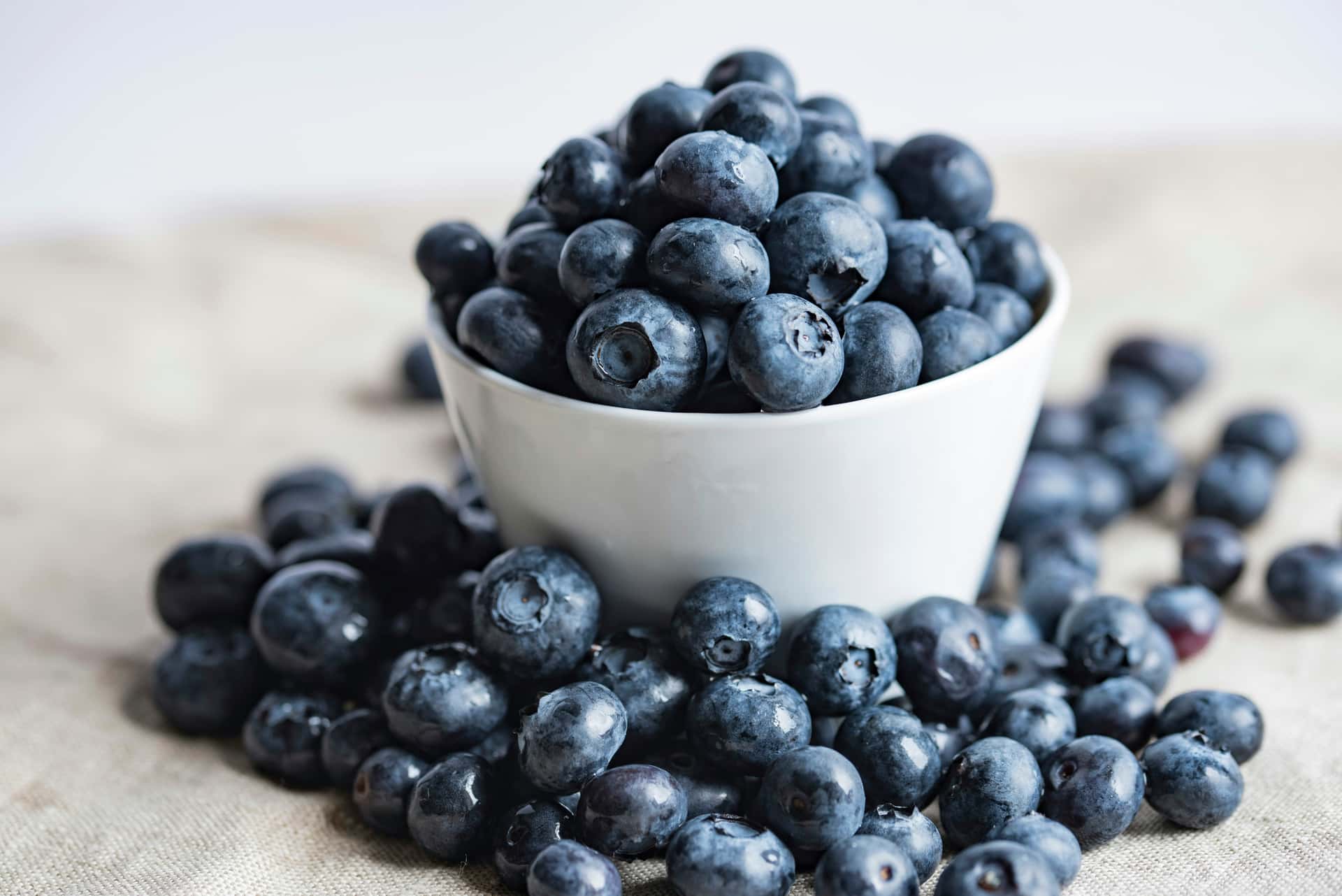 Blueberries spilling from a white ceramic bowl