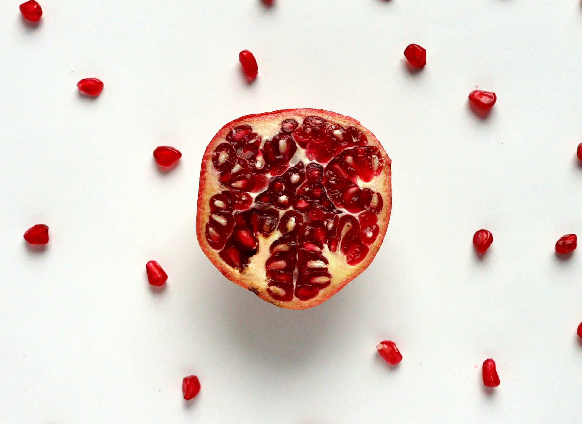 A pomegranate cut open with loose arils