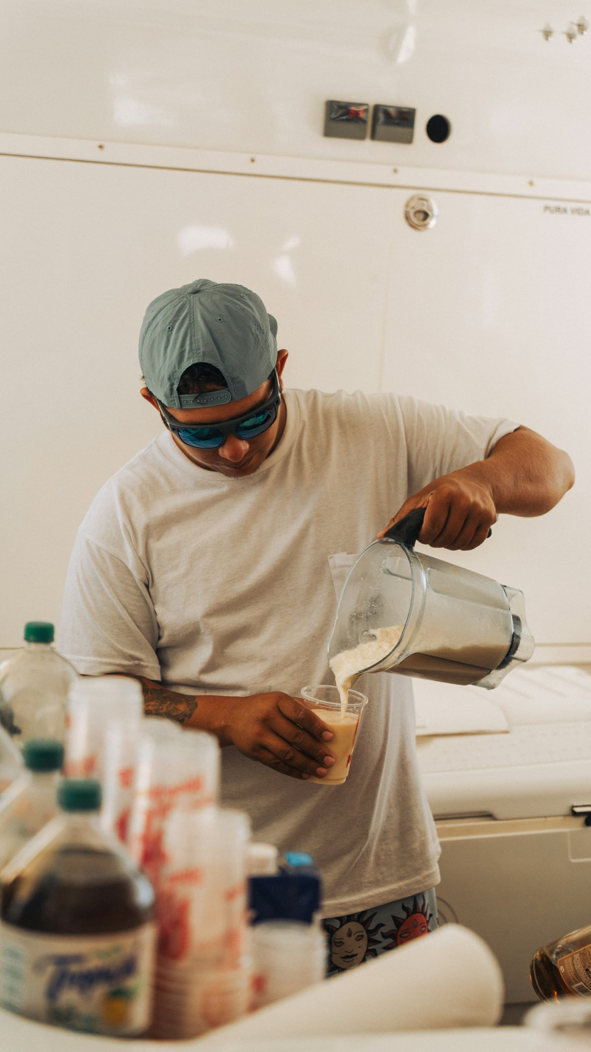 A man pouring a freshly blended smoothie from the blender jug into a glass